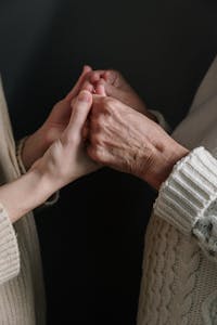 Two generations connect through holding hands, symbolizing love and unity.